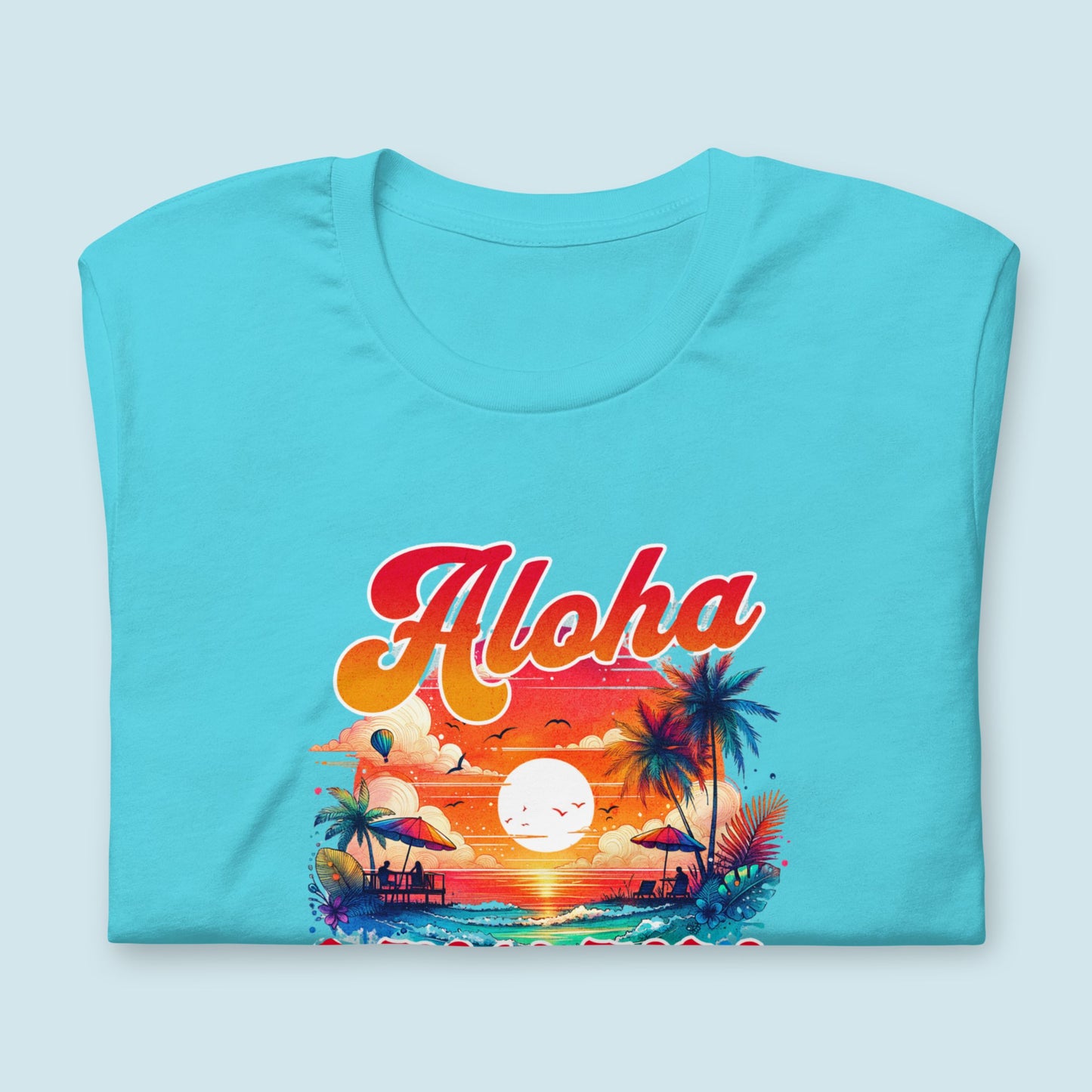 Turquoise t-shirt with 'Aloha' design featuring a sunset and palm trees on a light blue background.