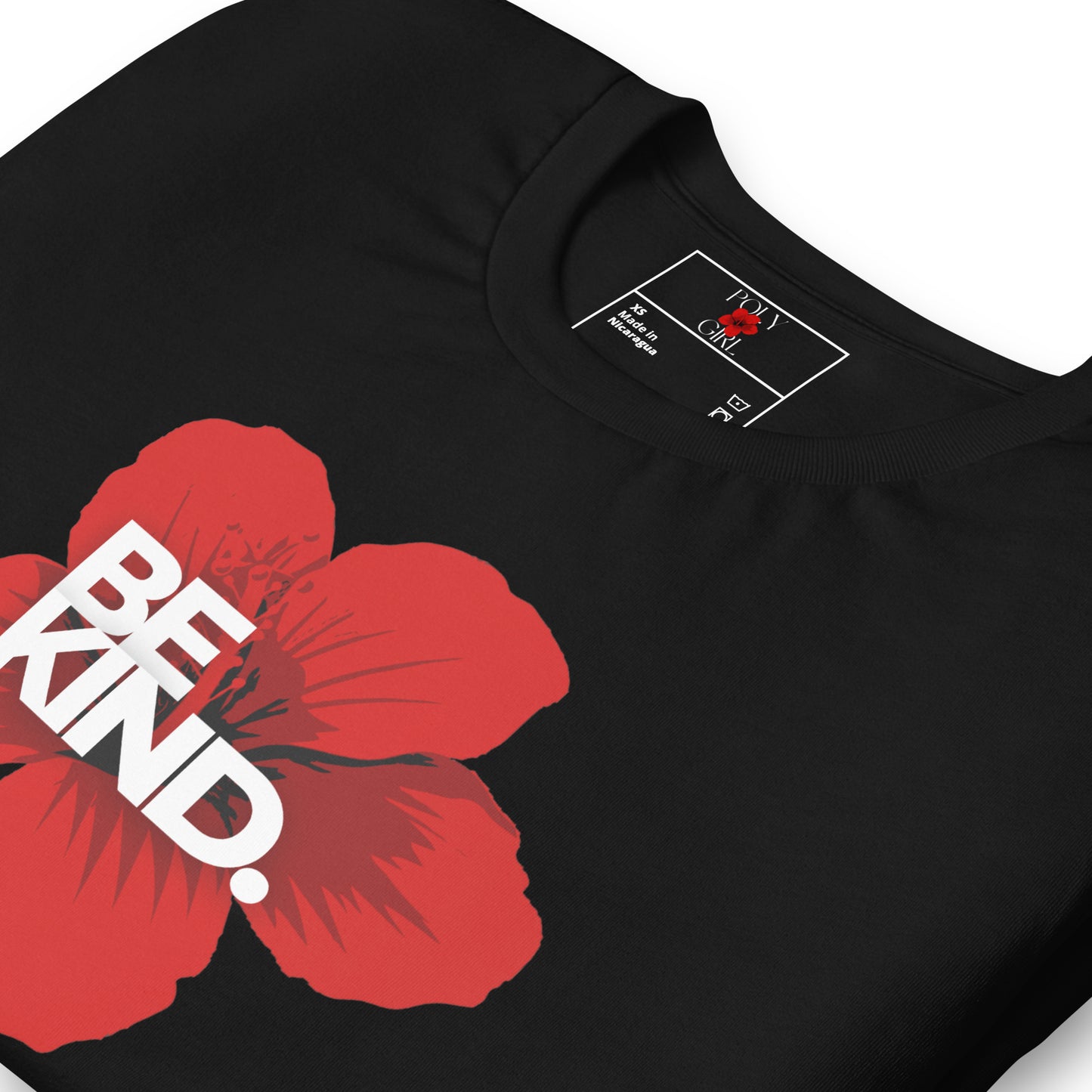 Be Kind Tshirt folded with front design showing red hibiscus