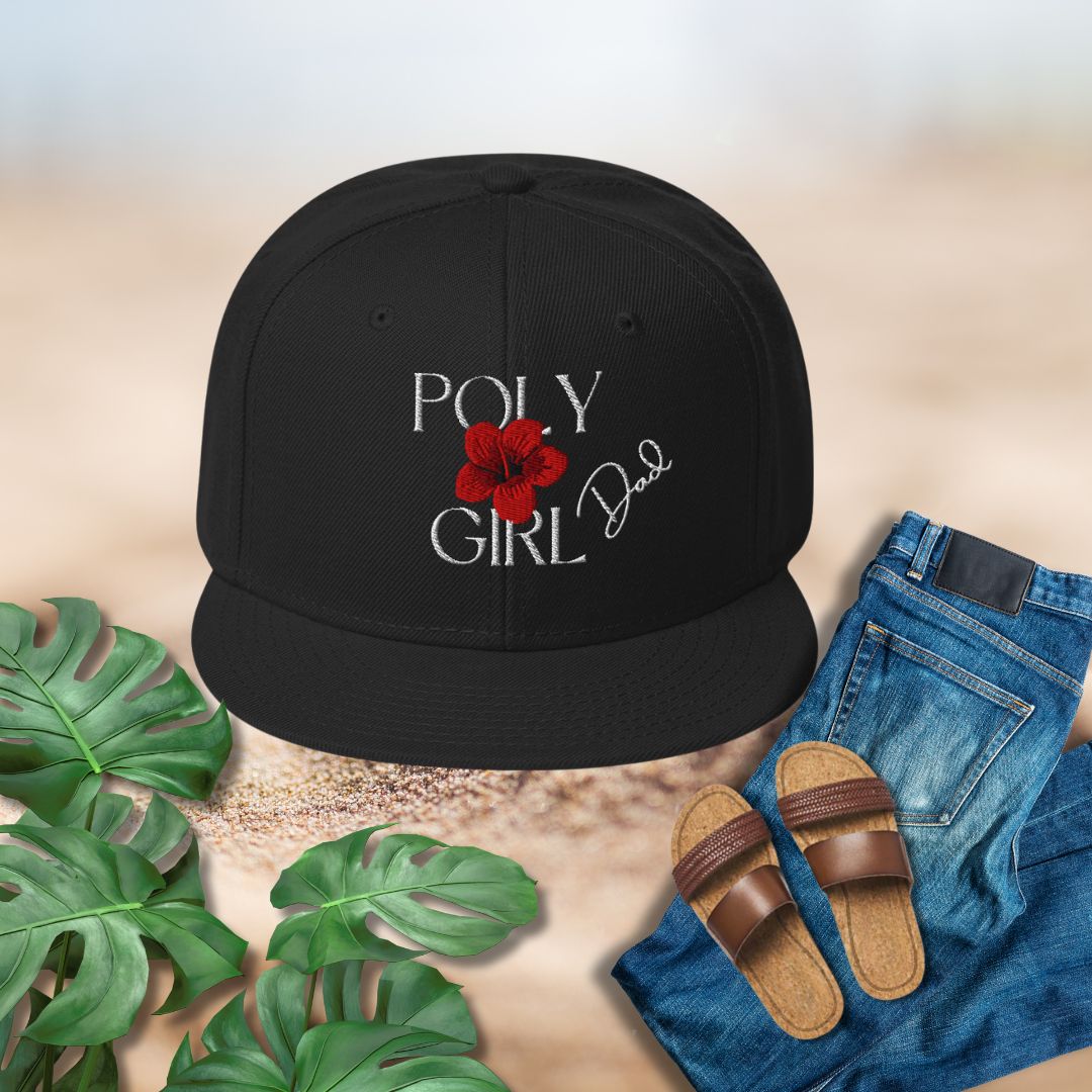 Black cap with 'Poly Girl' design, sandals, jeans, and plants on a textured surface