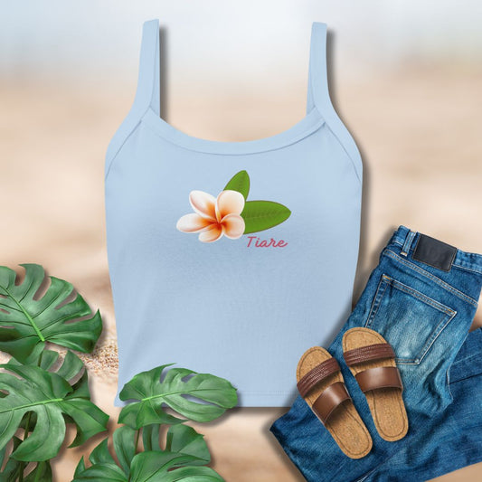 Light blue tank top with floral design and text, paired with jeans and sandals on a neutral background.