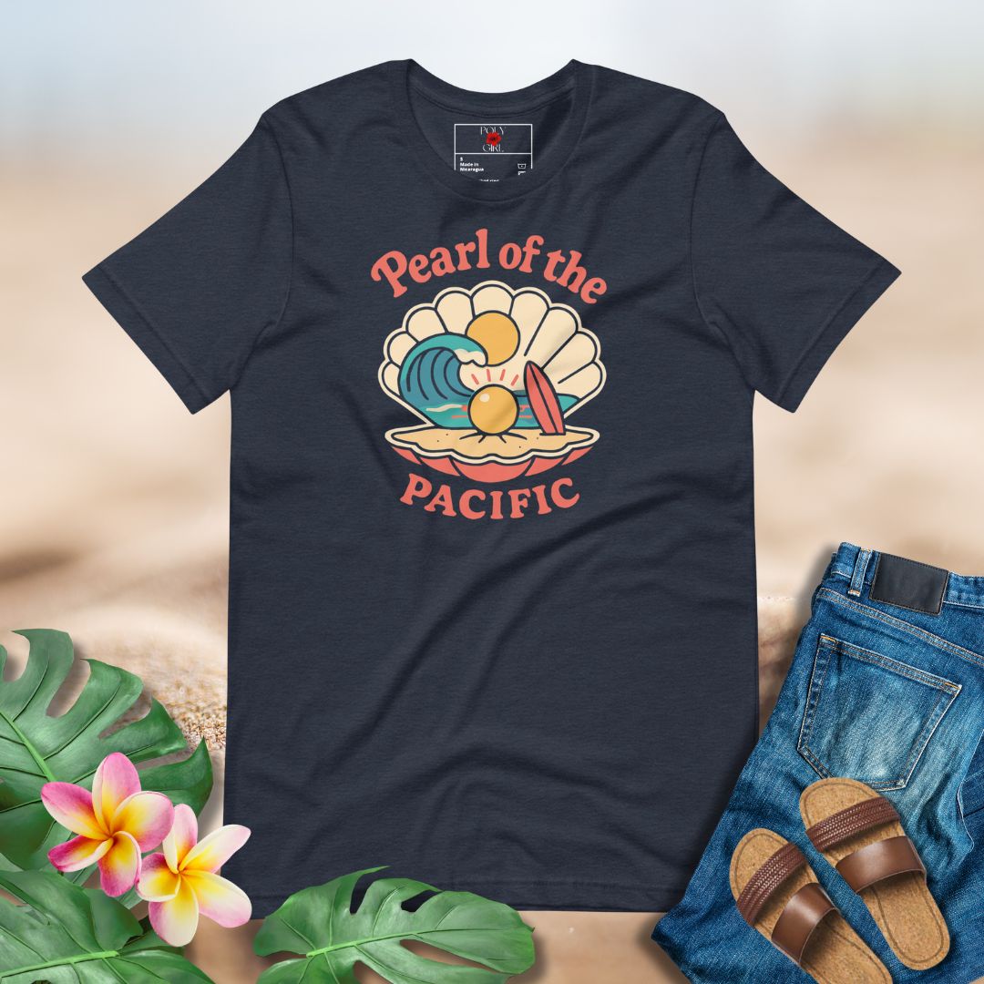 Navy blue t-shirt with 'Pearl of the Pacific' design on a sandy background with flowers and sandals.