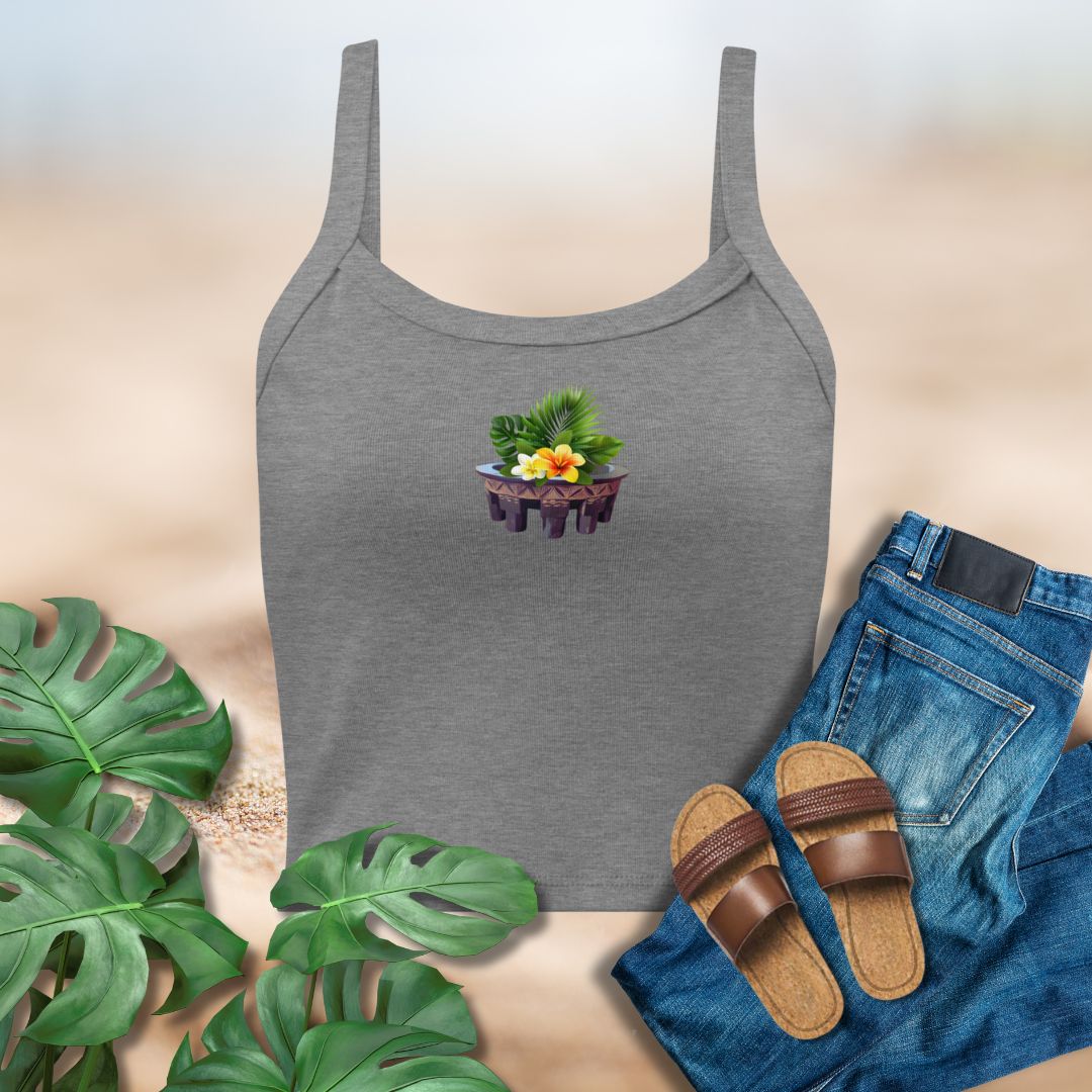 Gray tank top with a colorful design, blue jeans, brown sandals, and green leaves on a beige background