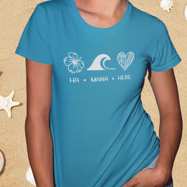 Person wearing a blue t-shirt with white graphics and text on a sandy background