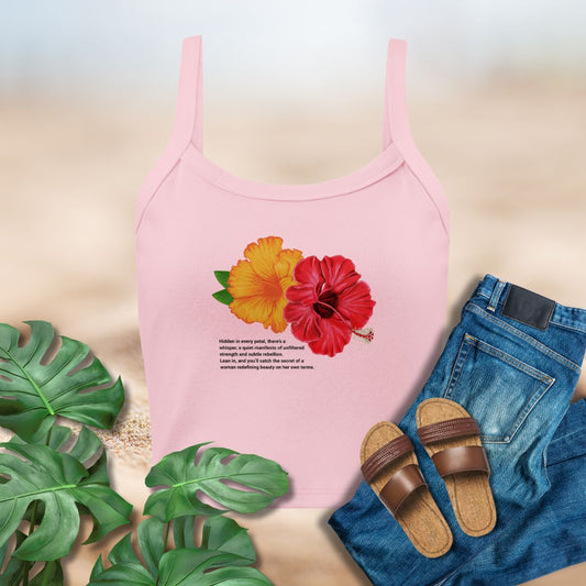 Pink tank top with floral design, sandals, jeans, and leaves on a light background