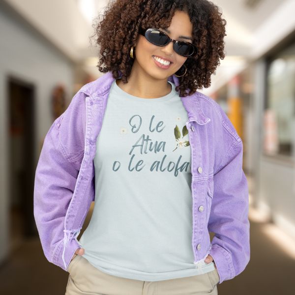 Woman wearing a light green tshirt with the words O le Atua o le alofa written on light green and blue t-shirt by Poly Girl