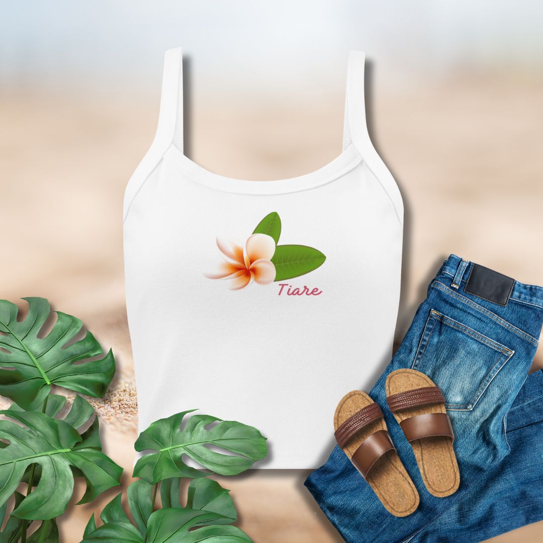 White tank top with frangipani flower design, paired with jeans and sandals on a neutral background.