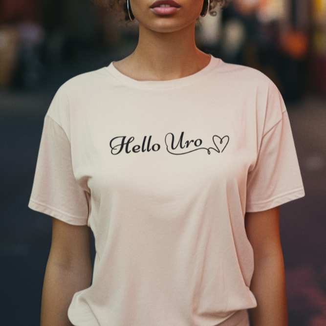 A woman wearing a beige-shirt with the text 'Hello Uro' printed on the front. Means Hello Gorgoeous in Fijian.