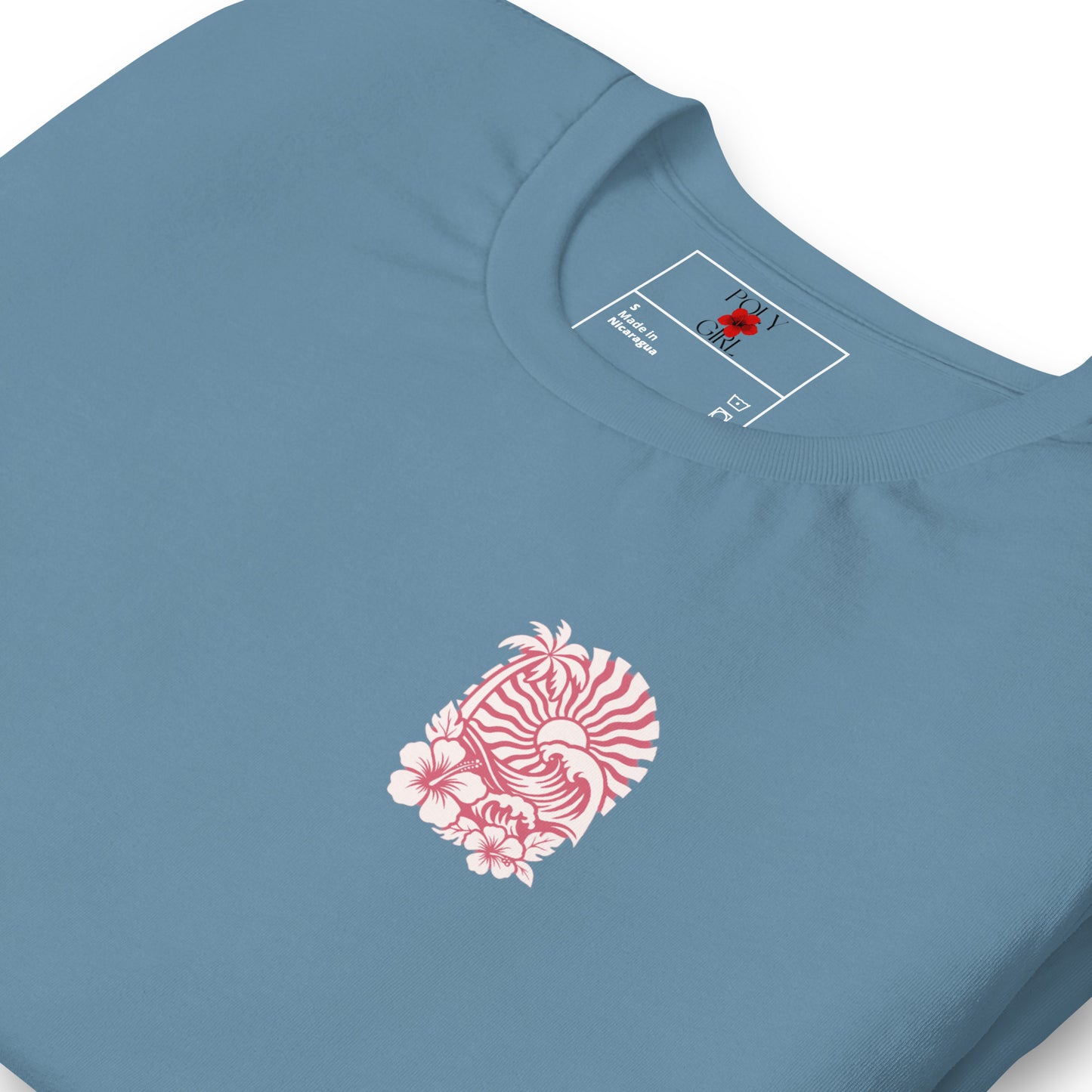Folded view of Island Wave & Bloom Tee showing pink hibiscus and wave artwork printed on left chest pocket area