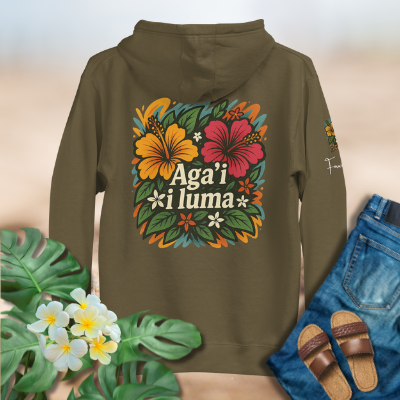 Green hoodie with Aga'i i luma hoodie floral design and text, surrounded by flowers and jeans on a beige background