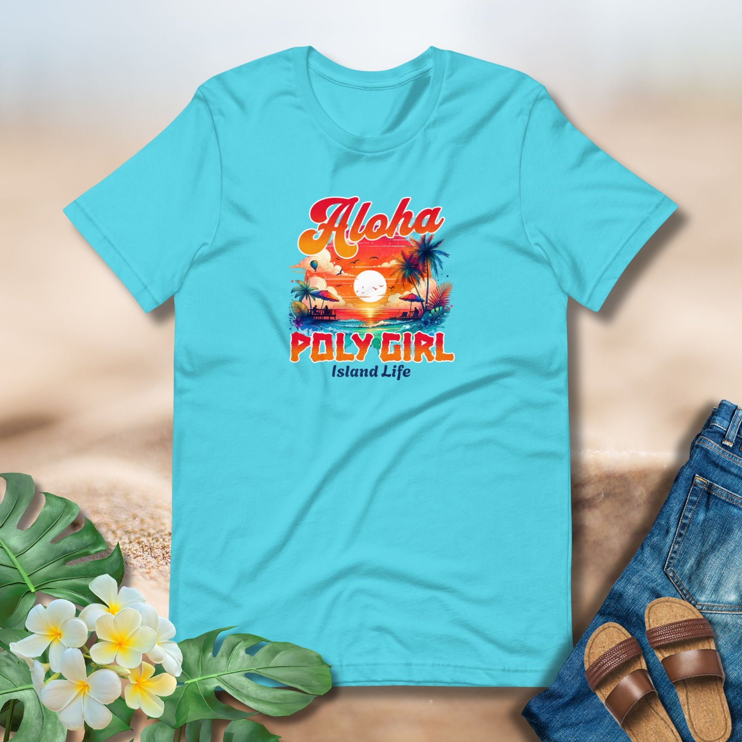 Turquoise t-shirt with 'Aloha Poly Girl Island Life' design on a sandy background with flowers and sandals.