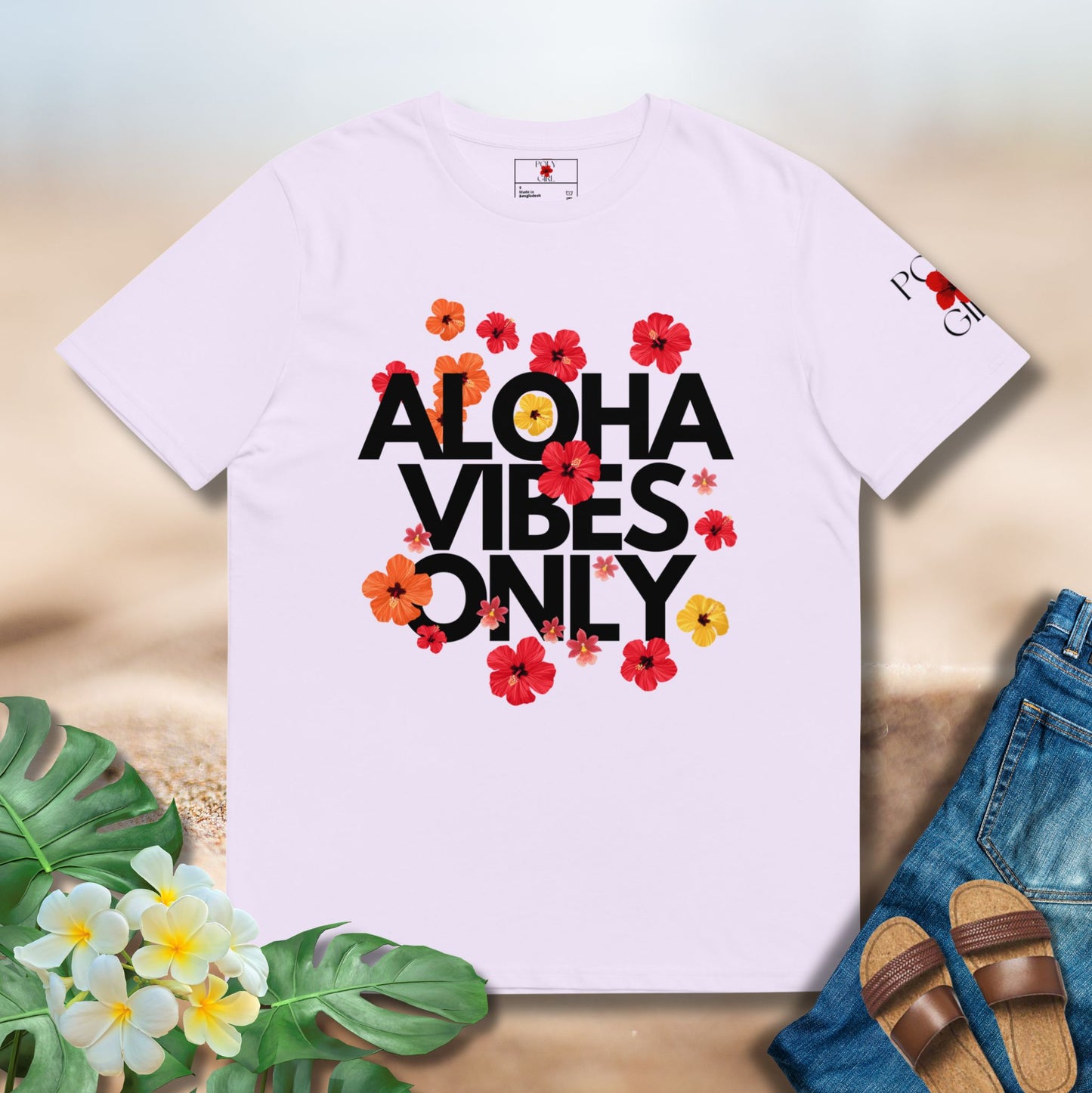 Lavender t-shirt with 'Aloha Vibes Only' text and floral designs on a wooden surface with flowers and sandals.