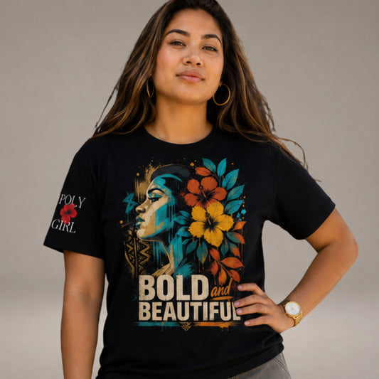 A woman wearing a black graphic t-shirt with a colorful design featuring a profile of a woman, tropical flowers, and the text 'BOLD and BEAUTIFUL' on the front, and 'POLY GIRL' on the sleeve, set against a plain gray studio background.