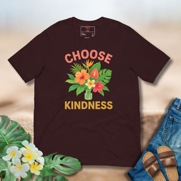 Brown t-shirt with 'Choose Kindness' design on a light background with flowers and jeans.