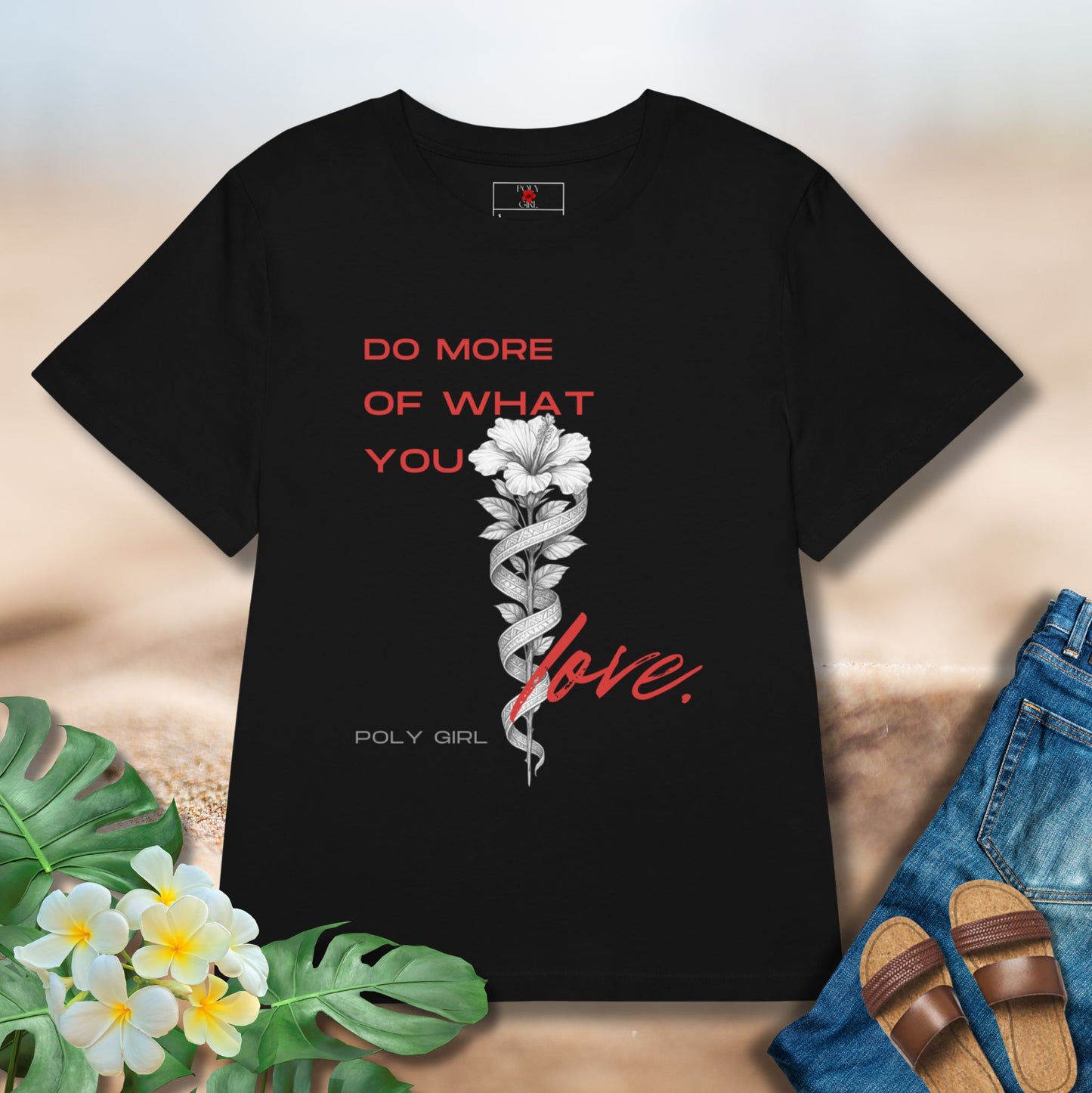 Black tshirt with the design of a white hibiscus and tapa with the words Do More Of What You Love