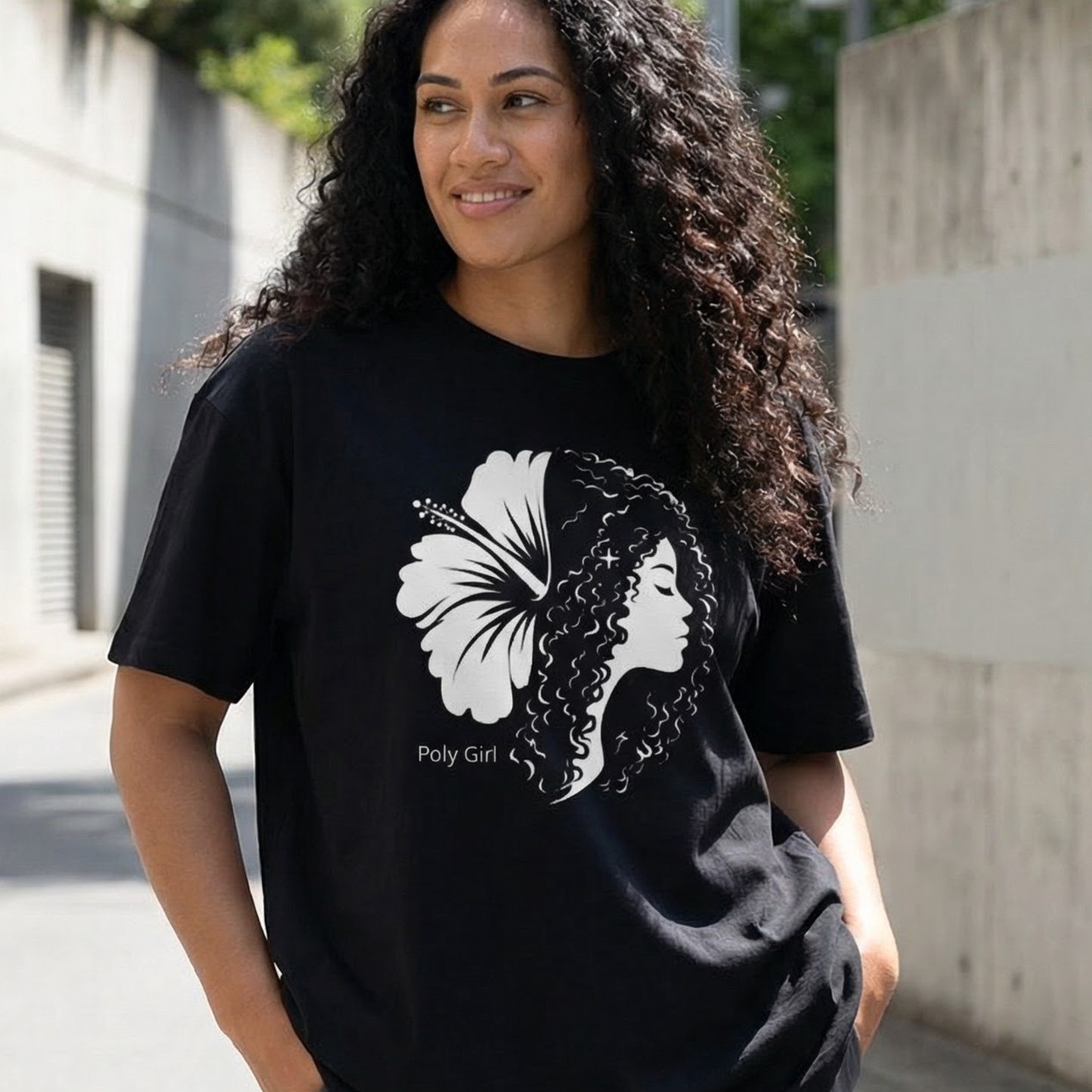Woman wearing a black t-shirt with a black and white graphic of a Poly Girl and hibiscus as the Duality tee.