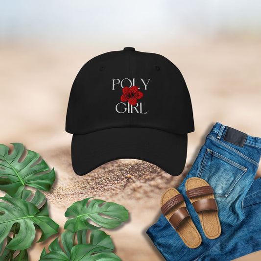 Black cap with 'Poly Girl' design, sandals, jeans, and plants on a textured surface