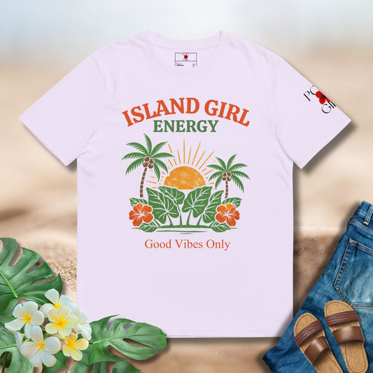 T-shirt with 'Island Girl Energy' design on a wooden surface with flowers and sandals.