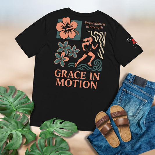 Black t-shirt with 'Grace in Motion' on back designed by Poly Girl, laid flat on plain background with green leaves and jeans. 