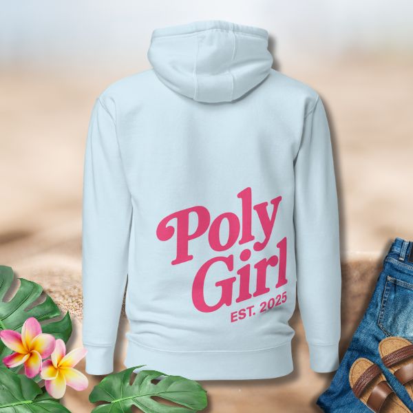Light blue hoodie with 'Poly Girl EST. 2025' text on a neutral background with plants and sandals.