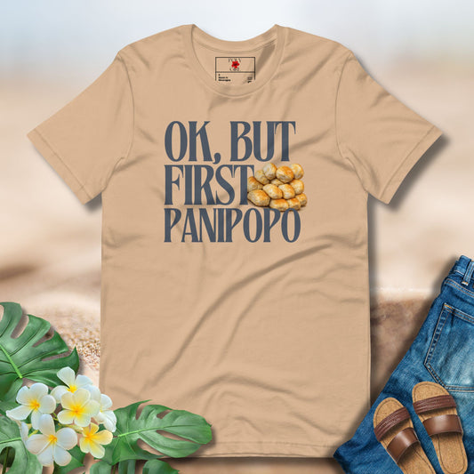 Beige t-shirt with 'OK, BUT FIRST PANIPOPO' text and graphics on a light background with flowers and jeans.