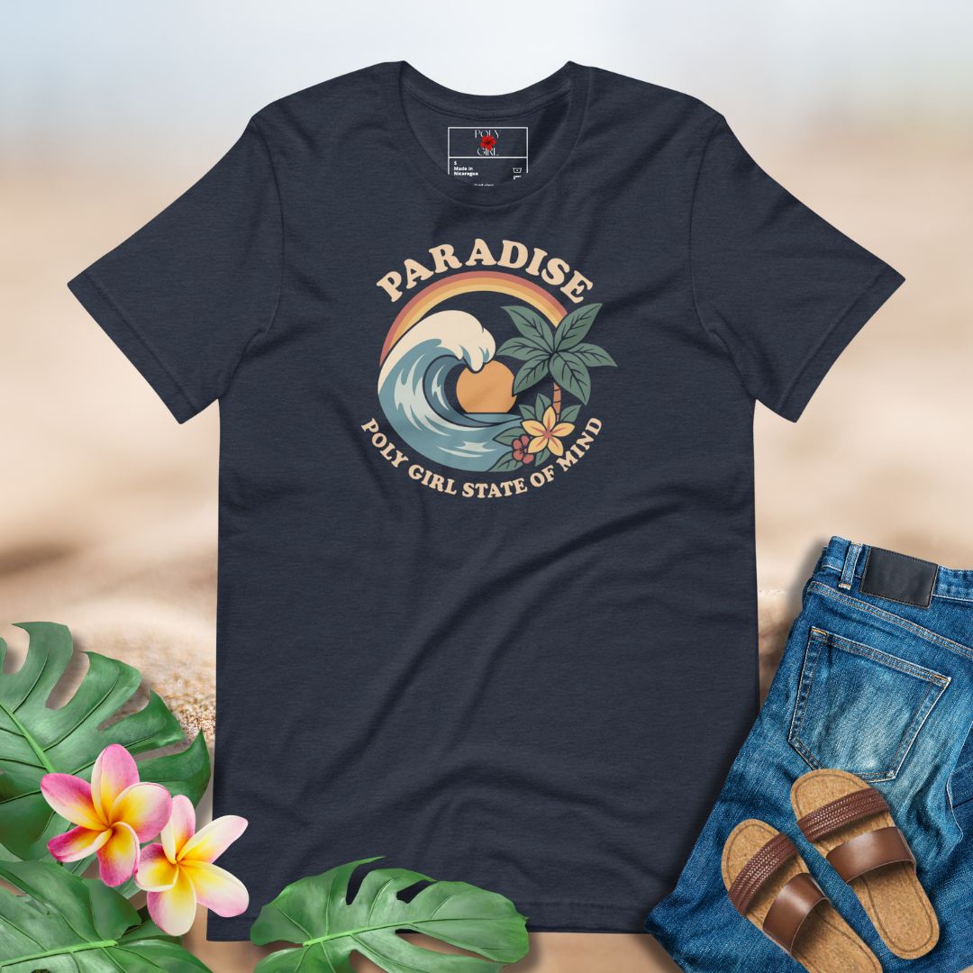Navy blue t-shirt with a tropical graphic design on a neutral background with floral and sand elements.
