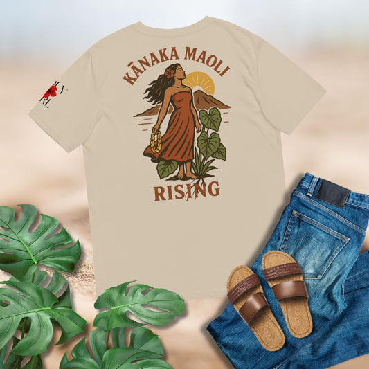 Beige t-shirt with a graphic design of Kanaka Maoli grounded and rooted with taro, sun and land behind her. Set against a mock up plain background, jeans, sandals, and tropical leaves.

