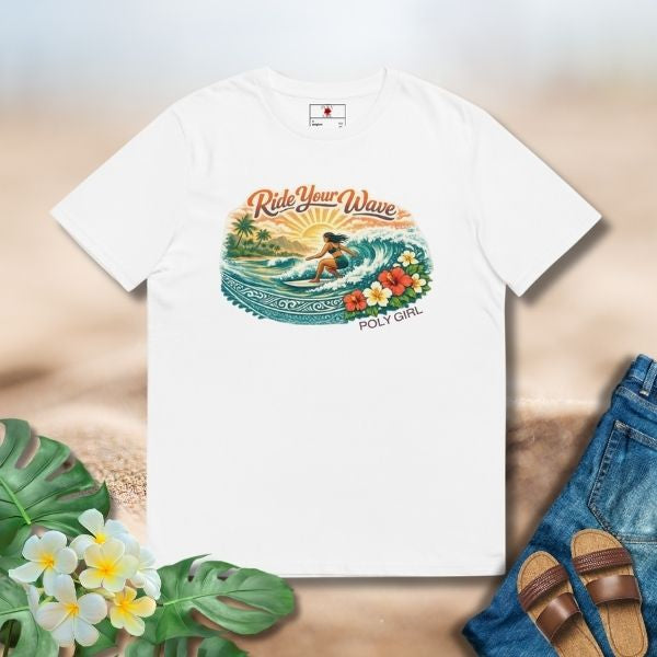 White tee featuring an island surf illustration with a woman riding a wave, tropical florals, sun, and Poly Girl logo.