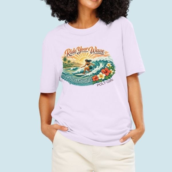 Lavender tee featuring an island surf illustration with a woman riding a wave, tropical florals, sun, and Poly Girl logo.