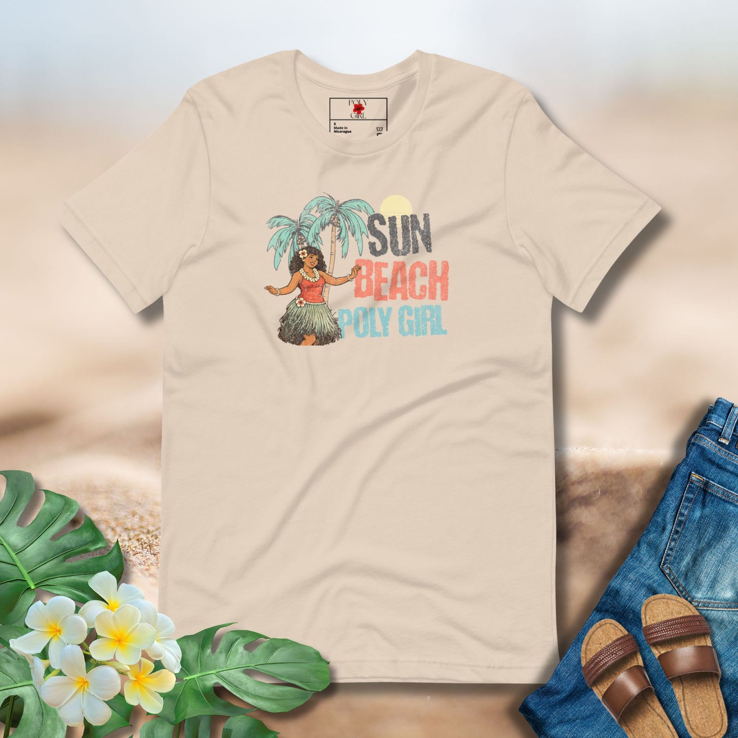 Beige t-shirt with a tropical design featuring a woman, palm trees, and text on a sandy background.
