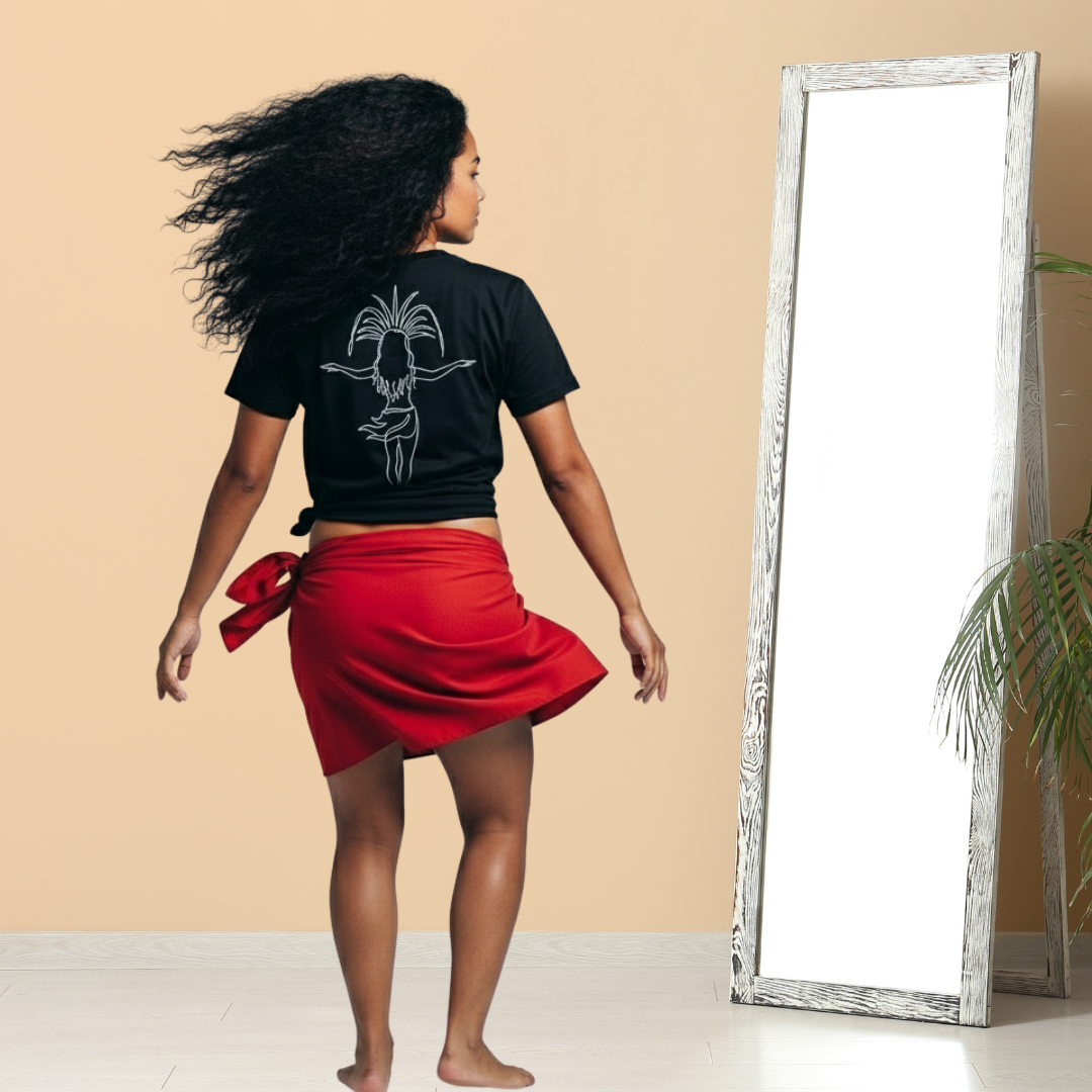 Woman wearing a black Poly Girl Tahitian Dancer t-shirt with a red pareo, standing in front of a mirror. 