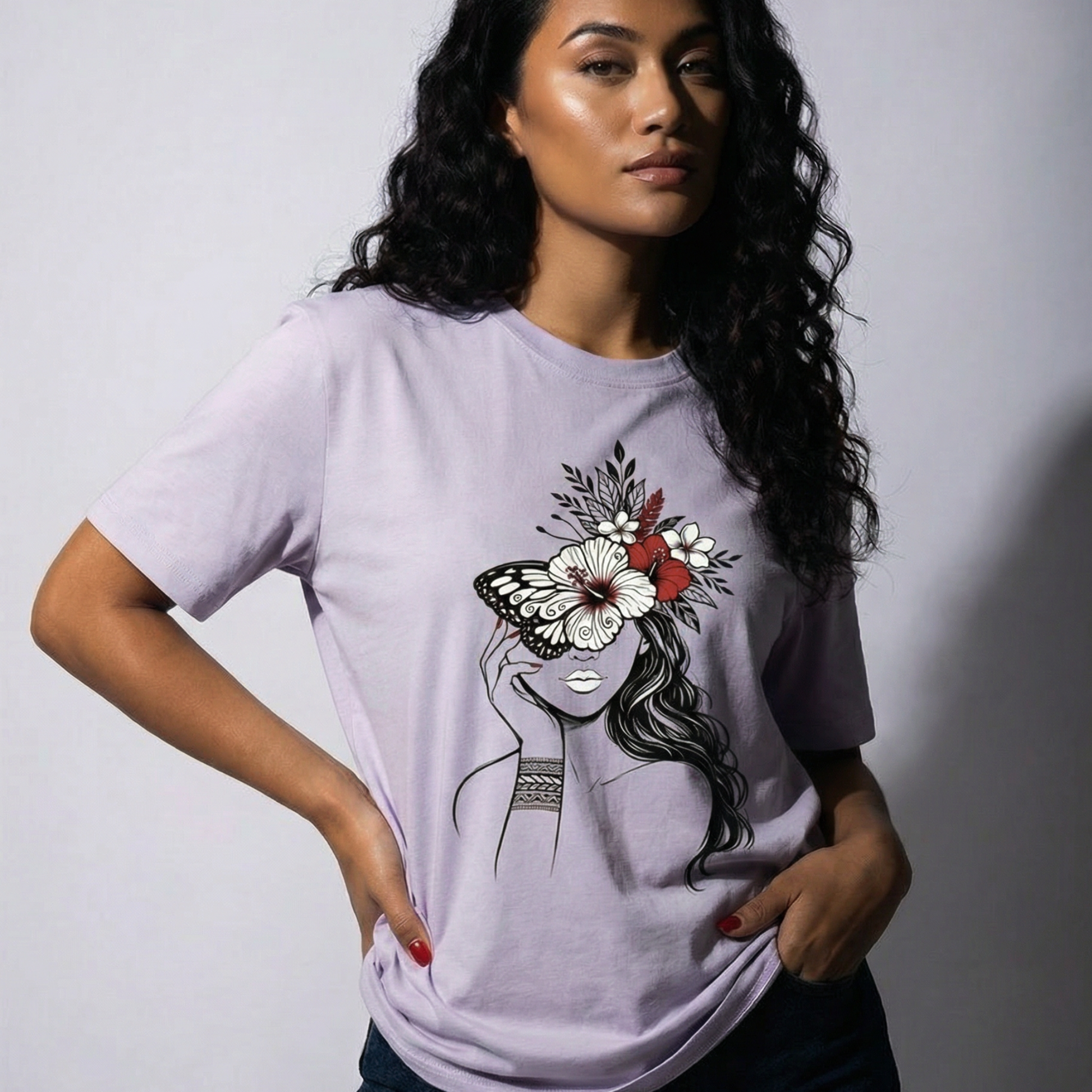 Woman wearing a light purple t-shirt with a graphic design of a woman's face with flowers and a butterfly.