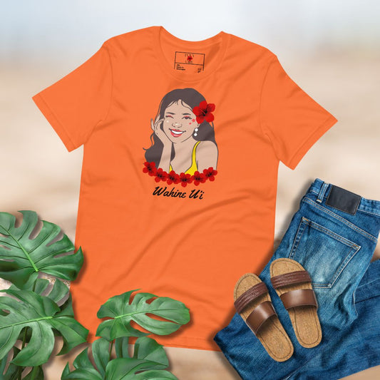 Orange t-shirt with a graphic design Wahine U'i surrounded by green leaves, sandals, and jeans.