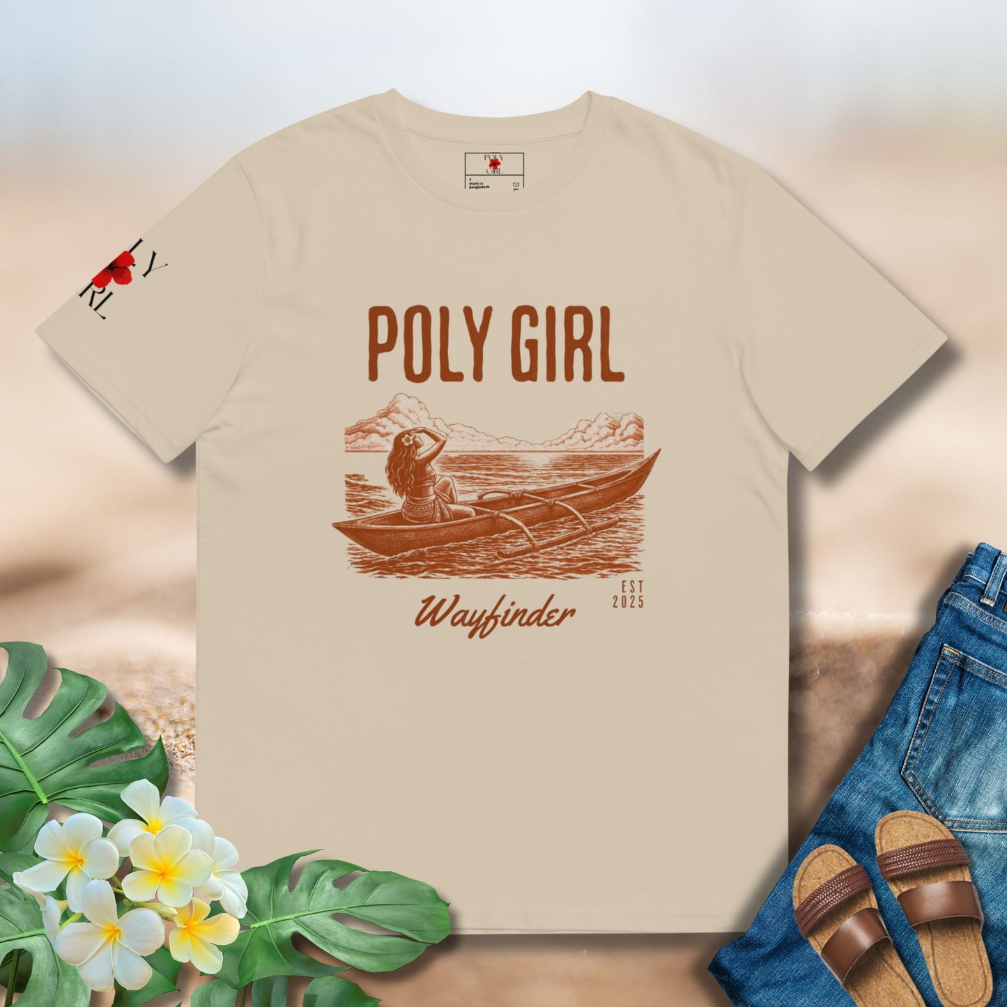 Beige t-shirt with 'Poly Girl Wayfinder' design on a neutral background with floral and denim elements.