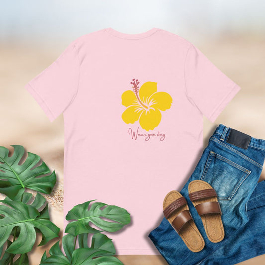Pink tshirt with yellow hibiscus and the words "Wear Your Story" printed on back off center. 