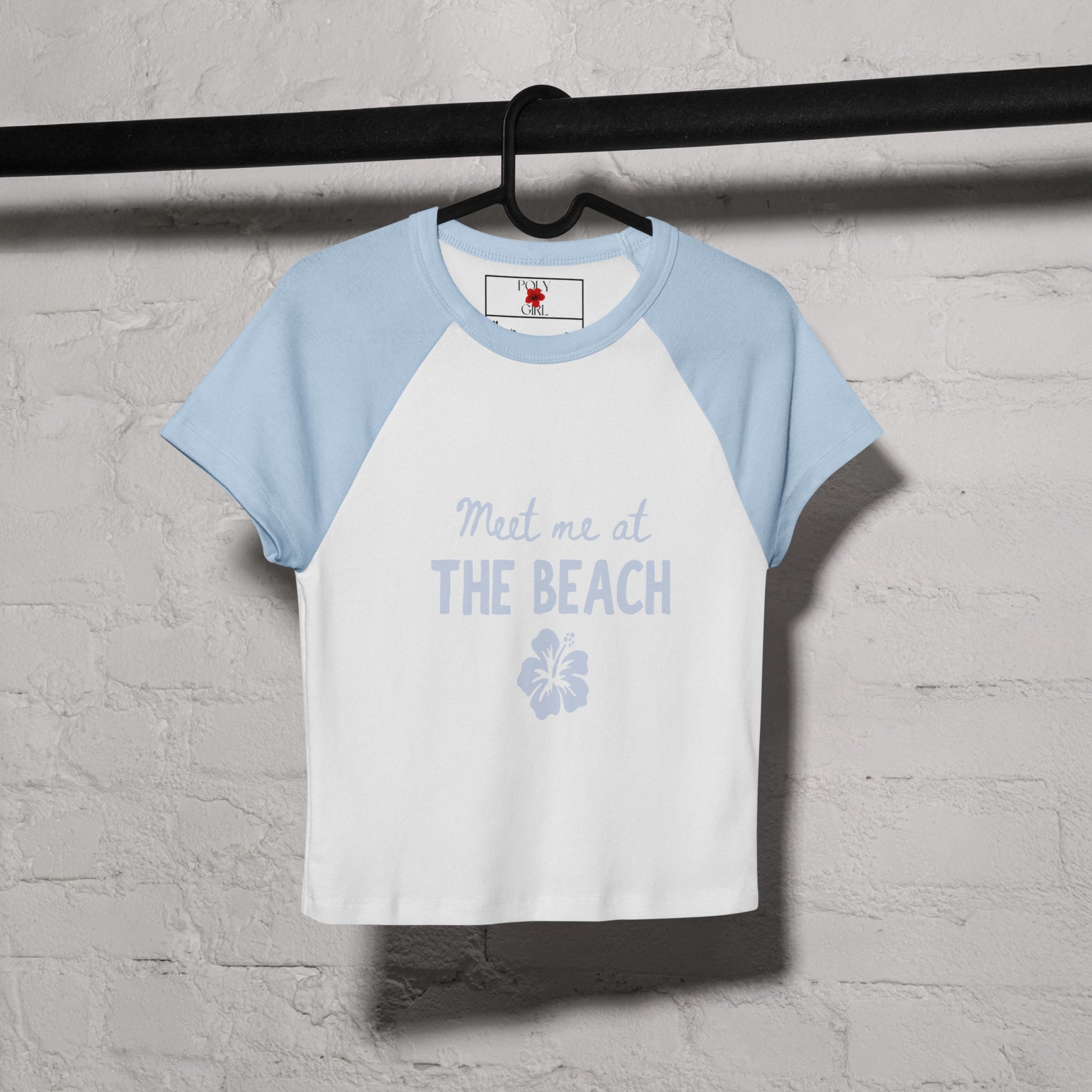 blue baby tee by poly girl with meet me at the beach design hanging on hanger