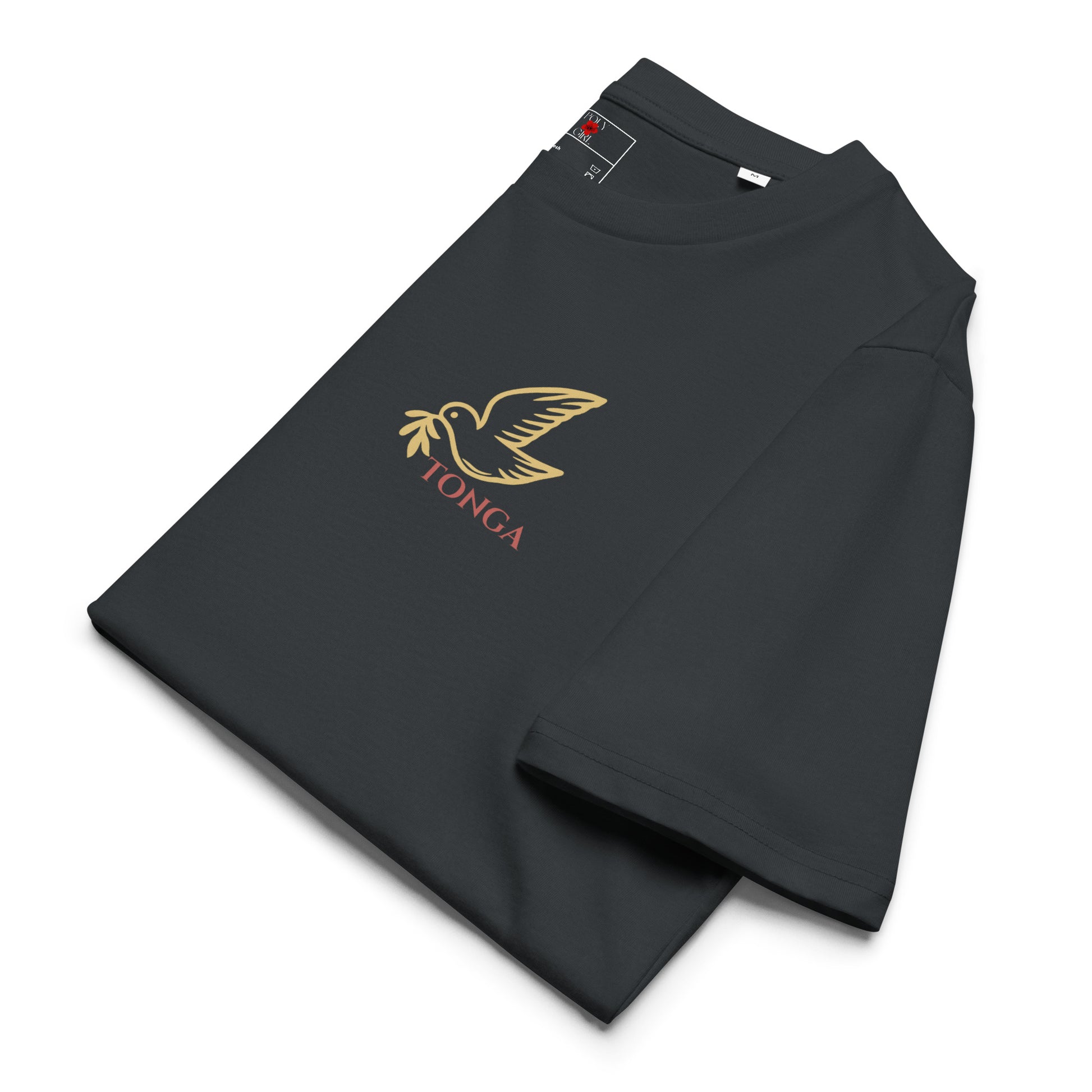 Close-up of Poly Girl Ko Hoku Tofi’a dark gray T-shirt, folded, with image of a dove in gold outline from the Tongan seal, printed on front chest pocket area.
